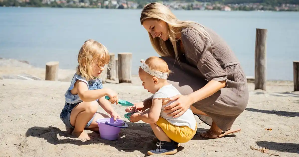 Mutter spielt mit ihren Kindern am See